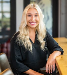 Image of Digital Marketing Coordinator Chelsea Cook in black long sleeve blouse at Paradigm Digital Group offices