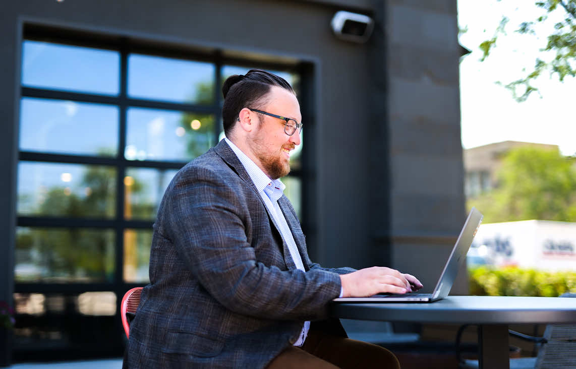 Image of digital marketing coordinator on laptop outside of Paradigm Digital Group office