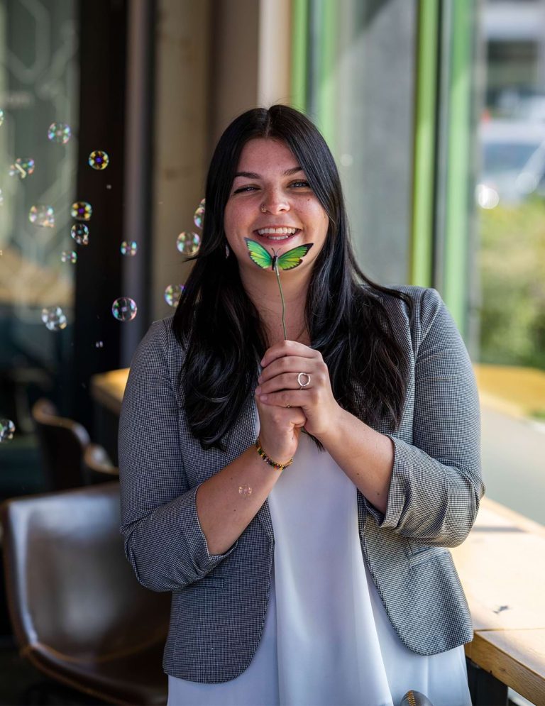 Image of Digital Marketing Coordinator, Kendall Cole, holding a butterfly pick, at Paradigm Digital Group offices