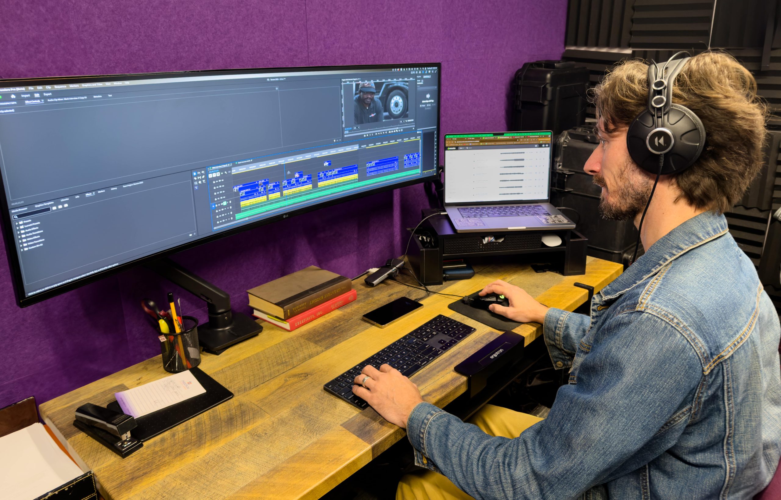 Evan Castor editing a video on a large arch computer monitor at his desk at our office