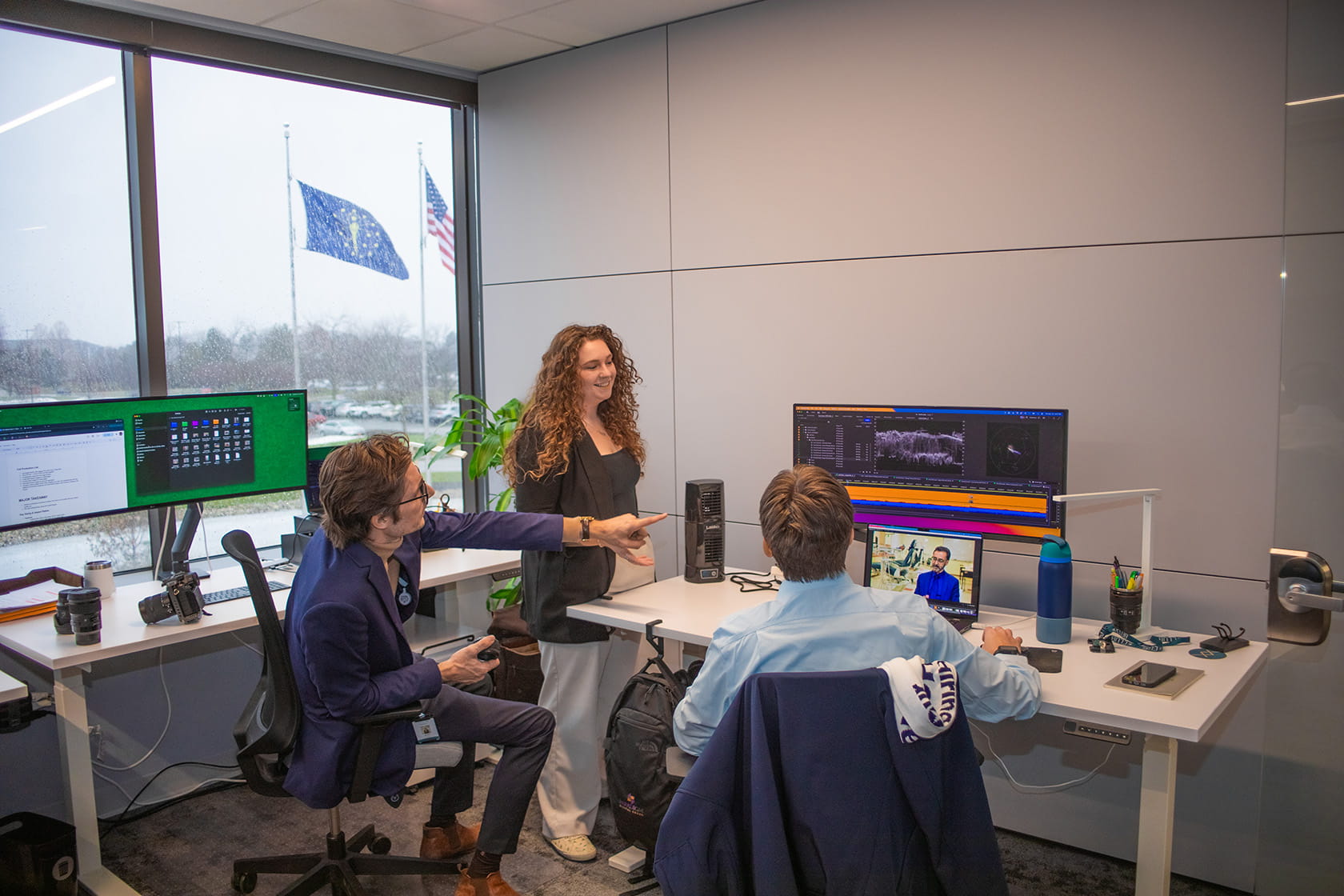Evan, Maxwell, and Destiny looking at large computer monitor in office