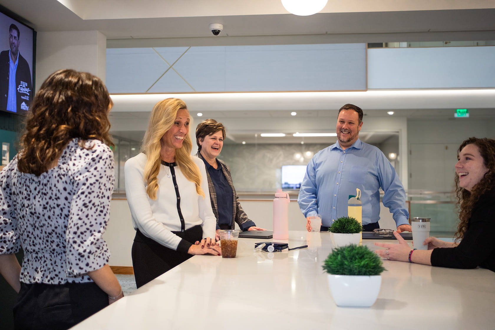 Members of Paradigm Digital Group team standing around kitchen island and chatting