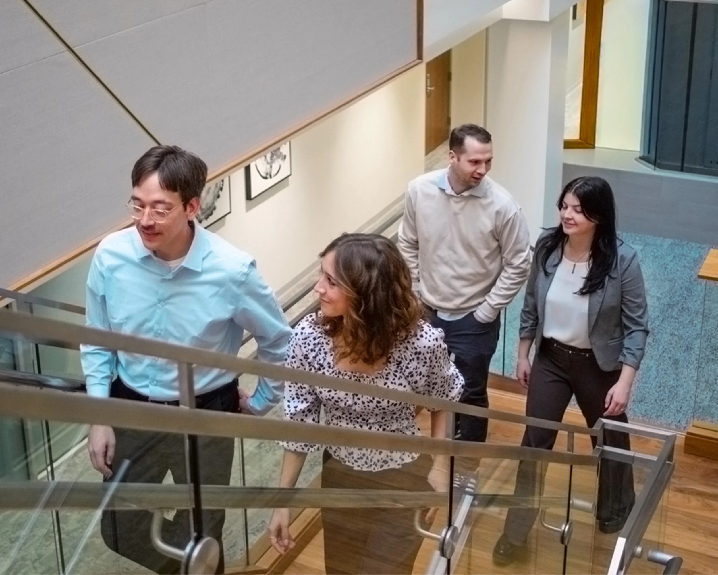Four members of the Paradigm Digital Group team talking and walking up staircase