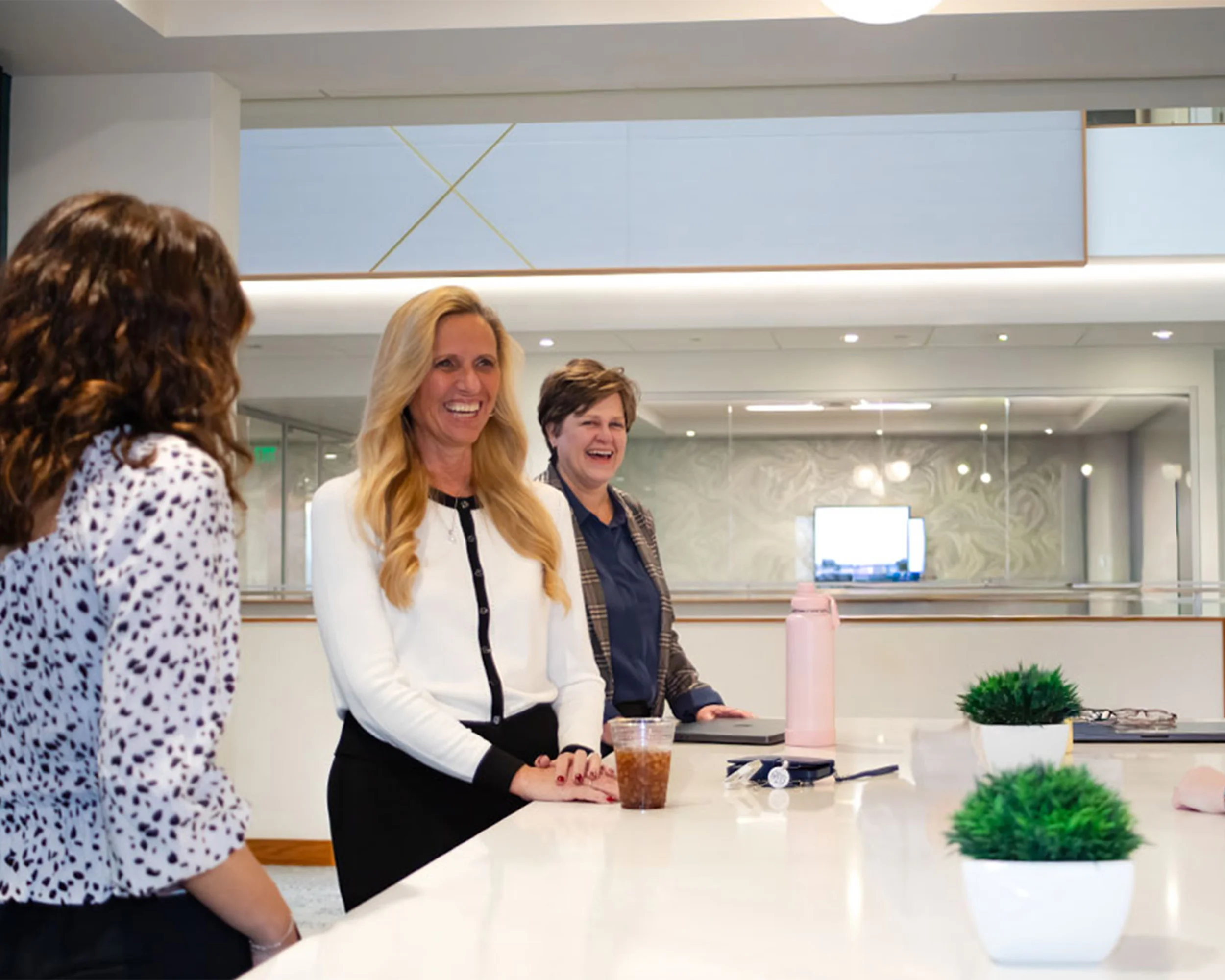 Members of Paradigm Digital Group team standing around kitchen island and chatting