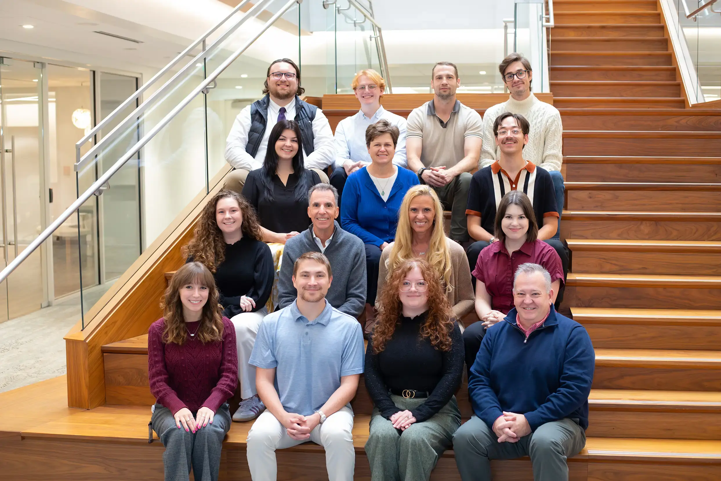 Paradigm Digital Group employees sitting on wooden stairs